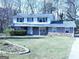 Charming front exterior featuring stone accents, a well-manicured lawn, and mature trees at 30 Hickory Dr, Stockbridge, GA 30281
