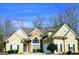 Charming home with stone and stucco exterior, arched window, manicured landscaping, and a well-maintained yard at 725 White Dove Dr, Mcdonough, GA 30253