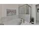 Bright bathroom featuring soaking tub with shower and tiled wall at 7920 Willoughby Ct, Alpharetta, GA 30005