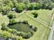 Birds-eye view features a peaceful pond surrounded by beautiful greenery and well-kept land at 115 Ebenezer Church Rd, Fayetteville, GA 30215