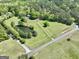 Stunning aerial view of a lush property with a pond, mature trees, and a well-maintained lawn at 115 Ebenezer Church Rd, Fayetteville, GA 30215
