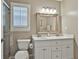 Bright bathroom with a double sink vanity, a toilet, a shower and a window with shutter blinds at 115 Ebenezer Church Rd, Fayetteville, GA 30215