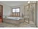 Bright and airy bathroom showcasing a soaking tub and glass enclosed shower with tiled walls at 115 Ebenezer Church Rd, Fayetteville, GA 30215