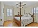 Well-lit bedroom with hardwood floors, a ceiling fan, and a grand four poster bed at 115 Ebenezer Church Rd, Fayetteville, GA 30215