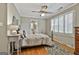 Comfortable bedroom with hardwood floors, a ceiling fan, and large windows with shutter-style blinds at 115 Ebenezer Church Rd, Fayetteville, GA 30215