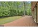 Exterior view of a beautiful backyard featuring a deck, lush trees, and stone elements at 115 Ebenezer Church Rd, Fayetteville, GA 30215
