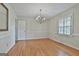 Bright dining room featuring hardwood floors, classic chandelier, and ample natural light from the window at 115 Ebenezer Church Rd, Fayetteville, GA 30215