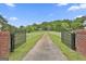 Scenic view of the long driveway leading to a stately property, framed by lush greenery and a secure gate at 115 Ebenezer Church Rd, Fayetteville, GA 30215