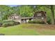 Charming two-story home featuring a blend of brick and wood siding, complemented by a lush, green lawn at 115 Ebenezer Church Rd, Fayetteville, GA 30215