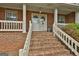 Charming front entrance with brick steps, white railings, and double doors with decorative wreaths at 115 Ebenezer Church Rd, Fayetteville, GA 30215