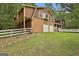 View of the barn house with a two-car garage and lush green lawn at 115 Ebenezer Church Rd, Fayetteville, GA 30215