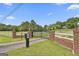 Property entrance with an ornate gate, brick pillars, and white fencing, creating a grand and secure entrance at 115 Ebenezer Church Rd, Fayetteville, GA 30215