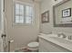 Cozy half bathroom featuring a white vanity, classic fixtures, and a window for natural light at 115 Ebenezer Church Rd, Fayetteville, GA 30215