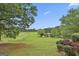 Expansive property with lush greenery, a pond, white fencing, and mature trees at 115 Ebenezer Church Rd, Fayetteville, GA 30215