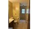 A yellow bathroom including a single vanity, a toilet, and a window above the tub at 130 Sandy Dr, Stockbridge, GA 30281