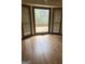 View of a bright bedroom with hardwood floors and a large window overlooking the back deck at 130 Sandy Dr, Stockbridge, GA 30281