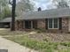 Charming brick home with an attached garage and a mature tree in the front yard at 130 Sandy Dr, Stockbridge, GA 30281