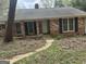 View of the charming brick home highlighting the front door and windows with black shutters at 130 Sandy Dr, Stockbridge, GA 30281