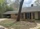 View of the charming brick home with an attached garage featuring a classic car inside at 130 Sandy Dr, Stockbridge, GA 30281
