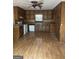 View of the kitchen with brown cabinets, white appliances, and a ceiling fan with light fixture at 130 Sandy Dr, Stockbridge, GA 30281