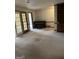 Spacious living room area featuring a piano, glass doors, and built-in shelving at 130 Sandy Dr, Stockbridge, GA 30281