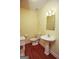 Cozy half bath with hardwood floors, pedestal sink, and decorative mirror at 118 Jasmine Way, Villa Rica, GA 30180