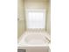 Bathtub with white lace curtain and silver fixtures at 118 Jasmine Way, Villa Rica, GA 30180