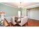 Warm dining space featuring hardwood floors, a chandelier, and view to the front door entrance at 118 Jasmine Way, Villa Rica, GA 30180