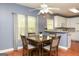 Bright dining area featuring a ceiling fan, hardwood floors, and a view to the kitchen at 118 Jasmine Way, Villa Rica, GA 30180
