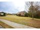 Brick-accented home with lush green lawns, featuring a driveway, mature trees, and manicured landscaping at 118 Jasmine Way, Villa Rica, GA 30180