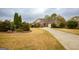 Well-manicured front yard, landscaped with a variety of trees, shrubs and a long driveway at 118 Jasmine Way, Villa Rica, GA 30180