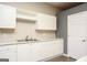 Bright kitchen with white cabinets, stainless sink, and light countertops at 118 Jasmine Way, Villa Rica, GA 30180