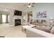 Bright living room featuring a fireplace, ceiling fan, and comfortable neutral-toned furniture at 118 Jasmine Way, Villa Rica, GA 30180