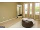 Cozy seating area in a bedroom, featuring a large mirror, ottoman, and abundant natural light at 118 Jasmine Way, Villa Rica, GA 30180