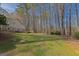 Expansive, tree-lined backyard featuring a lush lawn and mature trees offering privacy and natural beauty at 150 Mary Lynn Ln, Fayetteville, GA 30214