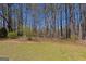 Backyard featuring mature trees and a well-maintained lawn, offering a serene outdoor space at 150 Mary Lynn Ln, Fayetteville, GA 30214
