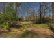 Secluded backyard path with a natural landscape of mature trees, offering a tranquil escape into nature at 150 Mary Lynn Ln, Fayetteville, GA 30214