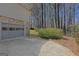 Exterior shot of garage with stone accent and spacious driveway in a serene setting at 150 Mary Lynn Ln, Fayetteville, GA 30214