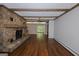 Open living space features a stone fireplace, wood floors, and exposed beams at 150 Mary Lynn Ln, Fayetteville, GA 30214