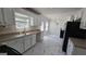 Well-lit kitchen featuring marble floors, stainless steel sink, white cabinetry, and modern appliances at 771 Franklin Mill Trce, Loganville, GA 30052