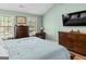 Well-lit bedroom with dual windows, wooden furniture, and a large television at 2515 Harbins Mill Dr, Dacula, GA 30019