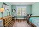 Bedroom with blue-green walls, hard wood floors, a window, bed, and desk at 2515 Harbins Mill Dr, Dacula, GA 30019