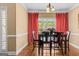 Charming dining area with a dark wood table, red drapes, and decorative stained glass window at 2515 Harbins Mill Dr, Dacula, GA 30019