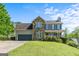 Inviting two-story home with a stone facade, attached garage, and well-manicured lawn under a bright blue sky at 2515 Harbins Mill Dr, Dacula, GA 30019