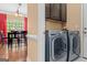 Convenient laundry room with side-by-side washer and dryer, cabinets and access to the dining area at 2515 Harbins Mill Dr, Dacula, GA 30019