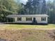 Charming single-story home features white siding, black shutters, and a covered carport for convenient parking at 300 Wood Rd., Hampton, GA 30228