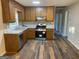 Well-lit kitchen with wooden cabinets, granite countertops, and stainless steel appliances offers style and functionality at 300 Wood Rd., Hampton, GA 30228