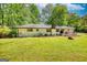 Spacious backyard with green lawn, painted brick home and a small deck with outdoor seating at 1200 Ridgeway Rd, Covington, GA 30014