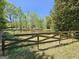 Scenic view of a pond bordered by a wooden fence and lush green trees and grass at 1200 Ridgeway Rd, Covington, GA 30014