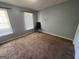 A well-lit bedroom with neutral walls and carpeted floor, featuring two windows and a work space at 1164 Interlaken Pass, Jonesboro, GA 30238